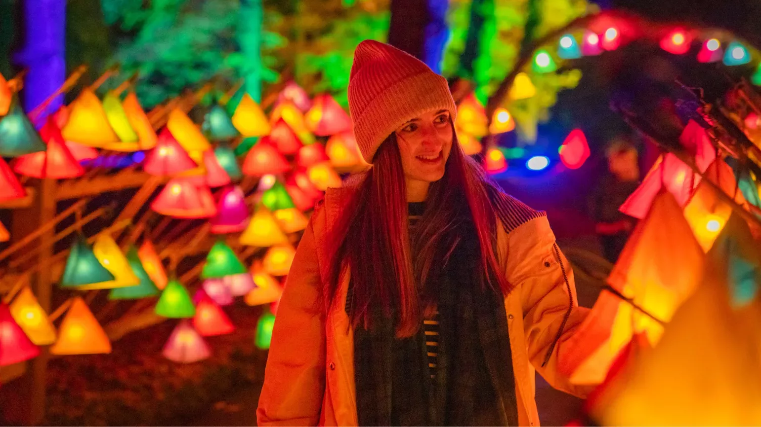 Woman in yellow coat surrounded by colourful lanterns