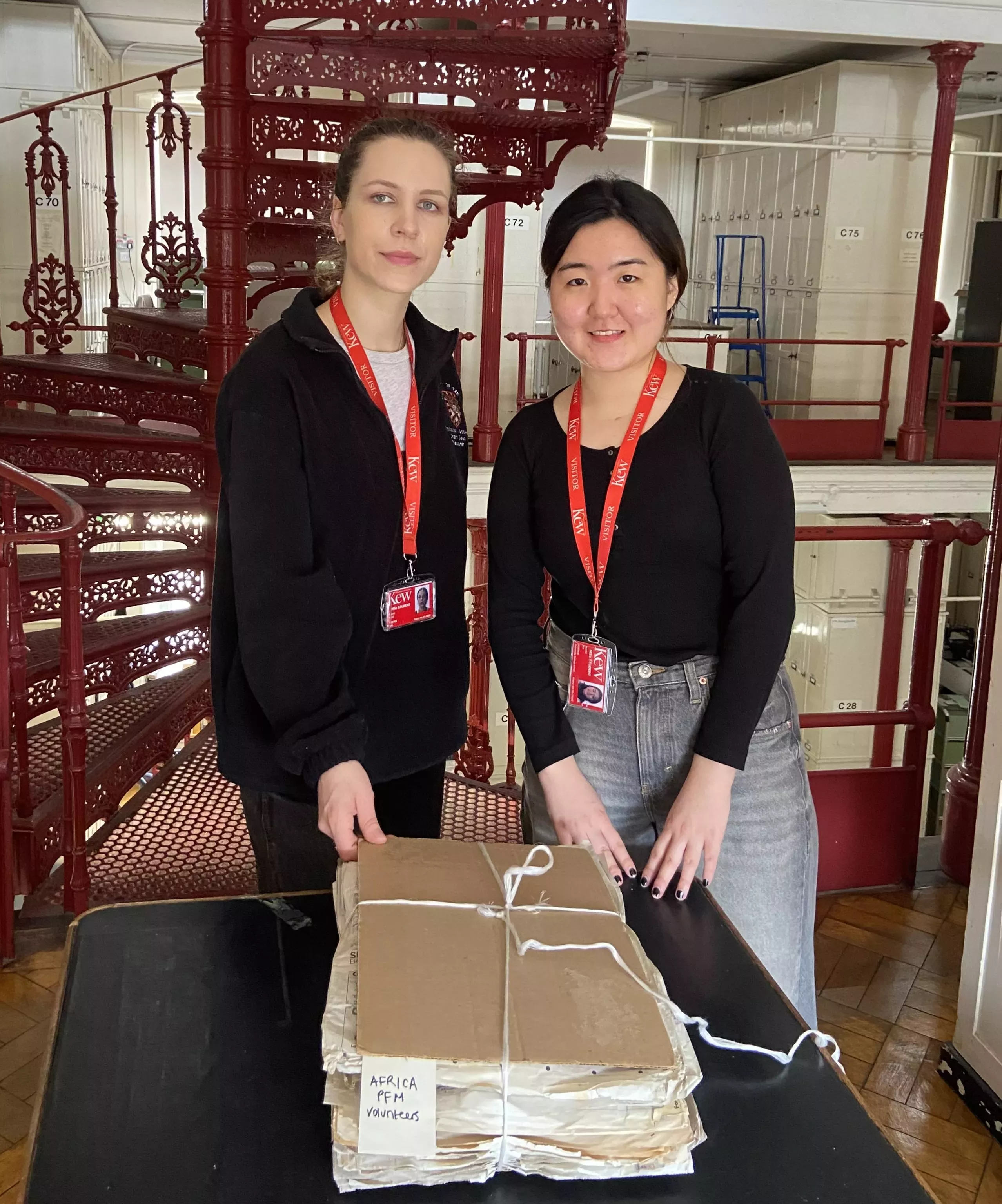 Two students and a folder of herbarium specimens in the kew herbarium