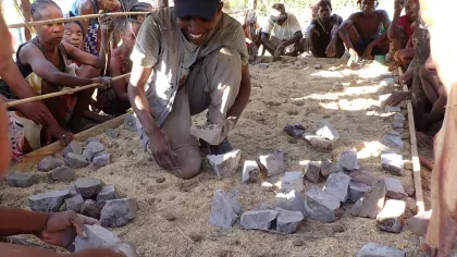 A member of the Kew madagascar team is demonstrating yam growing techniques to a crowd of onlookers