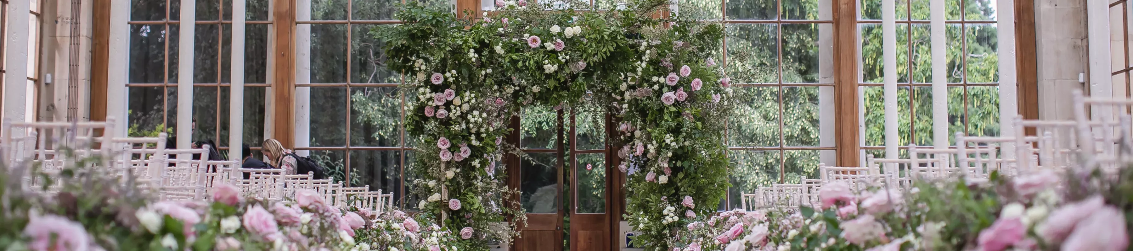 White chairs and colourful pink flowers adorning the Nash Conservatory at Kew