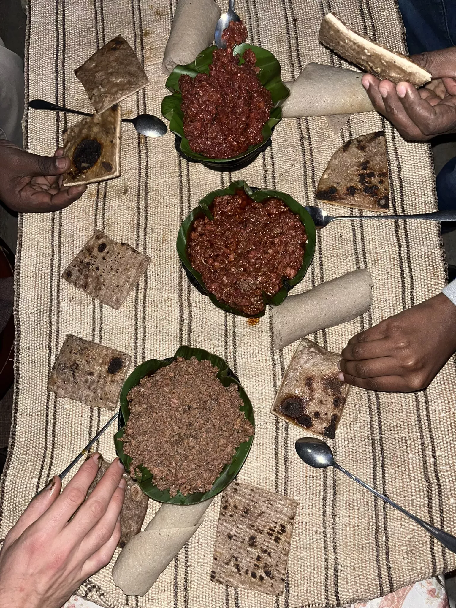 A table holds bowls of beef in sauce and flatbreads