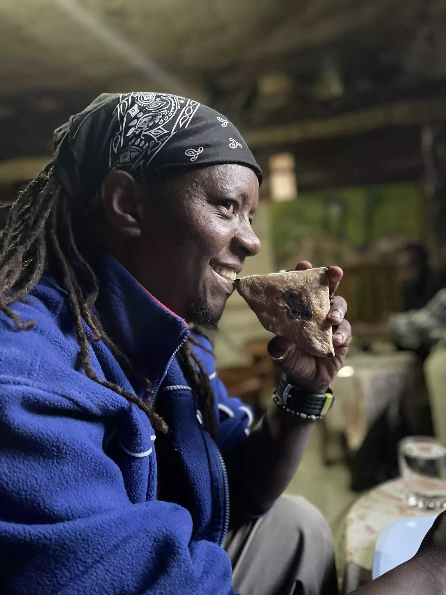 A man holds a flatbread-like food to his mouth