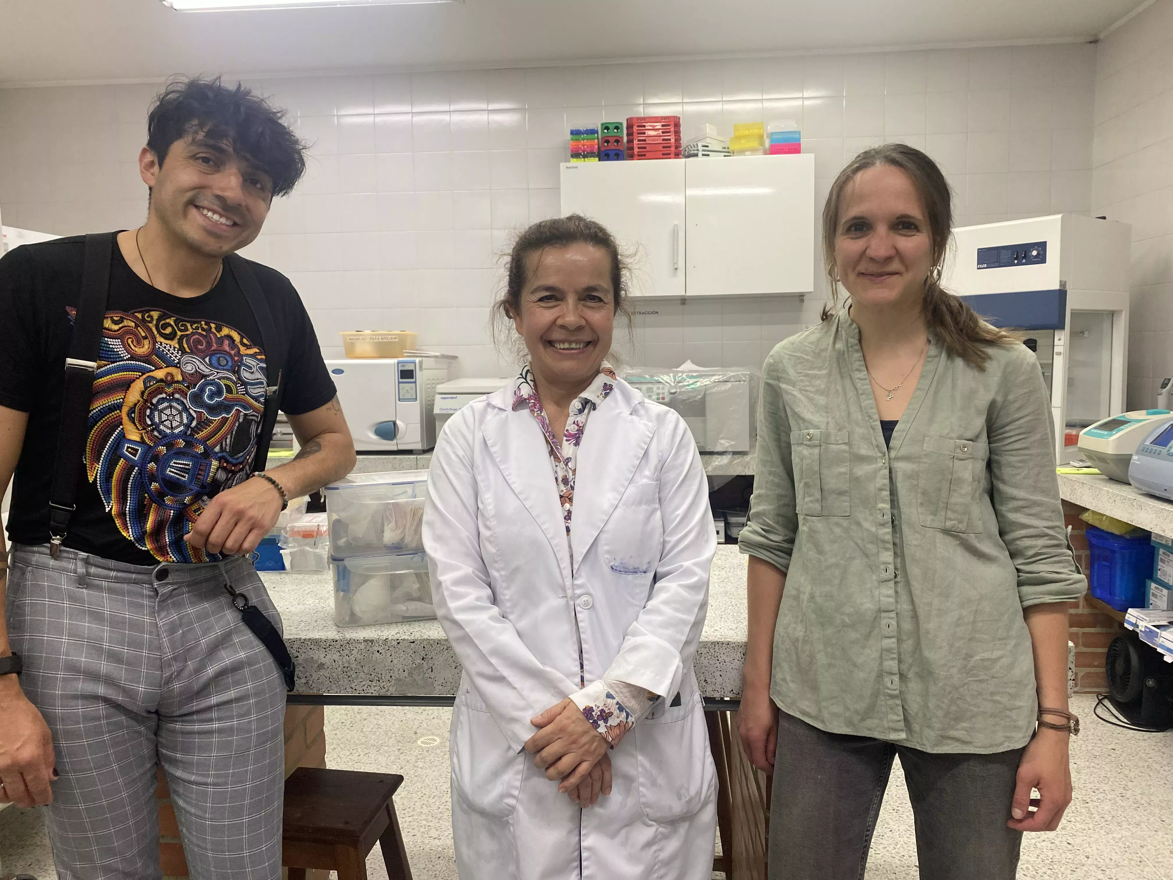 Three individuals pose for a photo in their lab