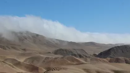 Fog crests a distant hilltop