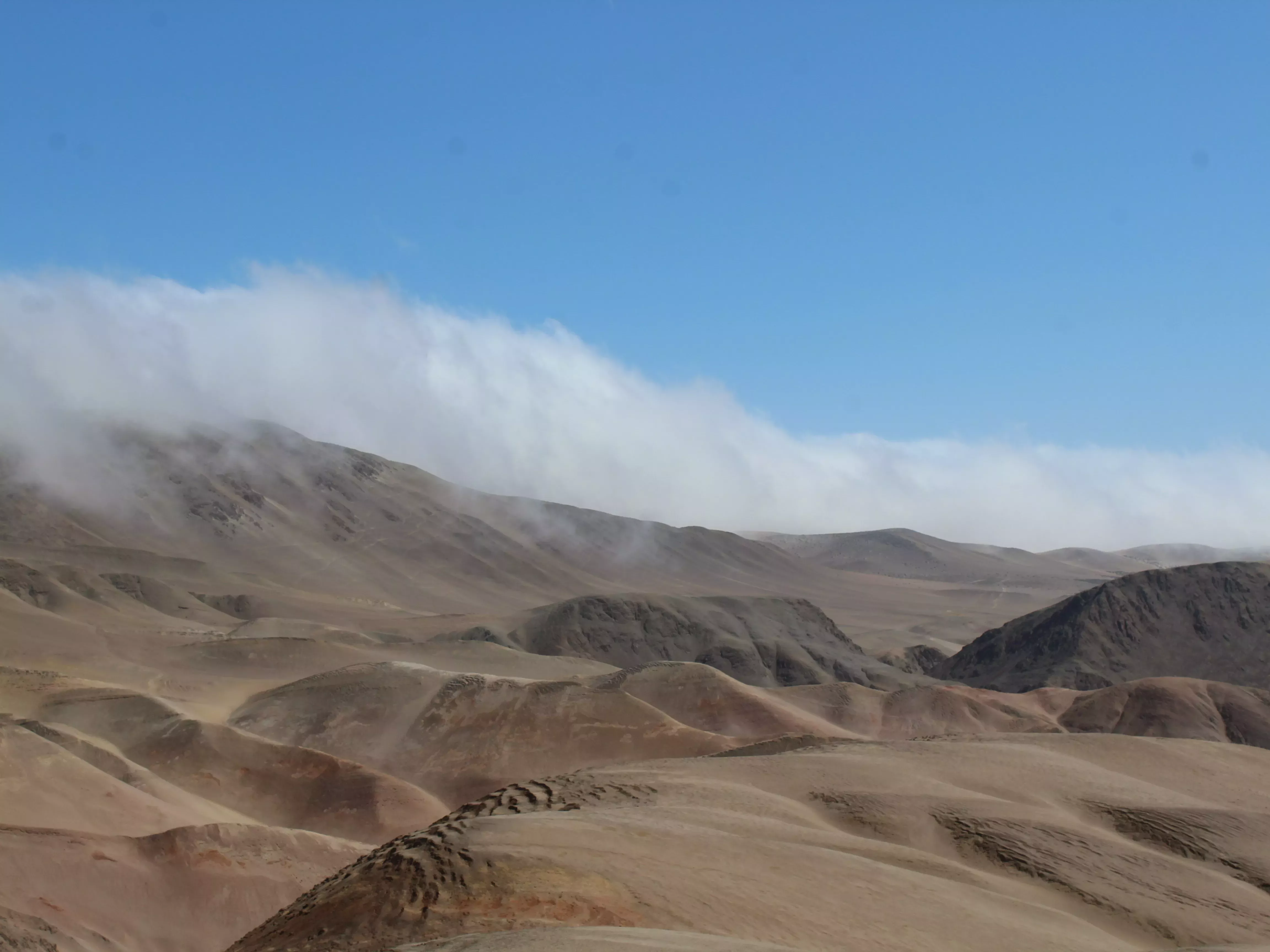 Fog crests a distant hilltop