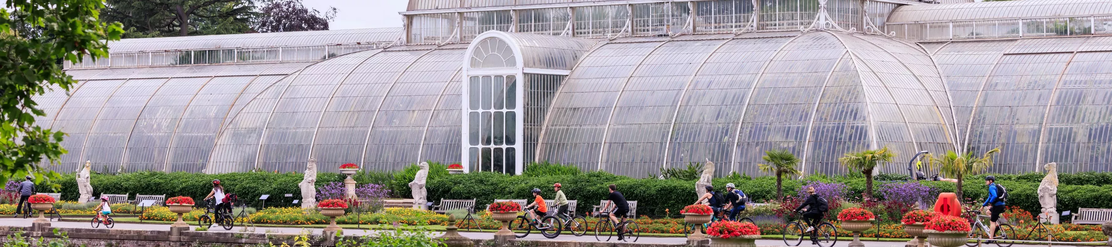 People on bikes outside a large glasshouse