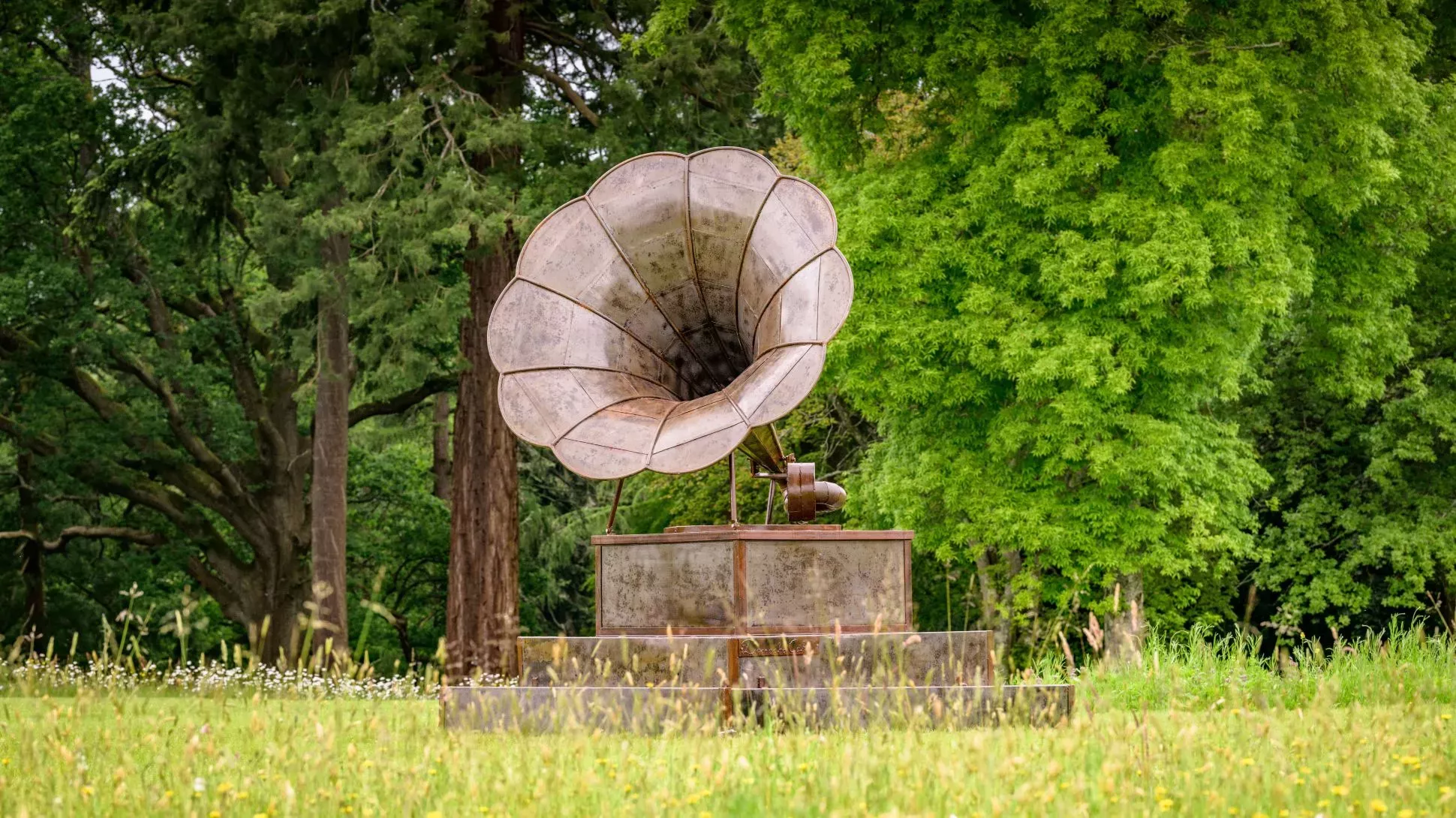 A large metal gramophone in a field