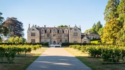 A wide shot of the Wakehurst mansion in summer