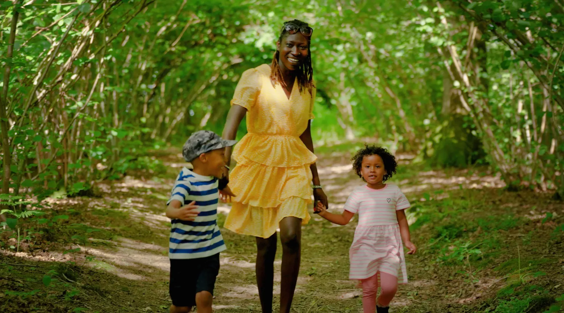 A family happily walk through a wooded area