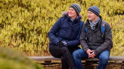 Two adults sat in Wakehurst gardens in winter